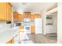 Bright kitchen featuring wood cabinets, white appliances, and vinyl flooring at 958 Kirkpatrick Pl # F, Greenfield, IN 46140