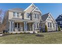 Beautiful two-story home featuring stone accents, a cozy front porch with rocking chairs, and manicured lawn at 78 Chatham Brook Dr, Westfield, IN 46074