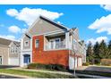 Two-story townhome with brick and siding exterior, attached garage, and balcony at 9774 Herring Gull Dr, Carmel, IN 46280