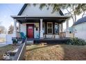 White house with black accents, red door, and a welcoming porch at 1601 Spruce St, Indianapolis, IN 46203