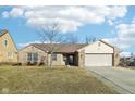 Brick ranch home with attached garage and landscaped lawn at 12334 Buckley Blvd, Cumberland, IN 46229