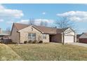 Brick ranch home with attached garage and spacious lawn at 12334 Buckley Blvd, Cumberland, IN 46229