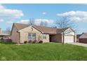 Brick ranch home with attached garage and spacious lawn at 12334 Buckley Blvd, Cumberland, IN 46229
