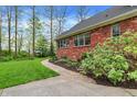 Stone walkway leads to the side of the house, with lush landscaping, creating a private outdoor retreat at 1398 Penny Ln, Greenfield, IN 46140