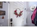White front door adorned with a lovely red wreath at 14024 Wimbleton Way, Fishers, IN 46037