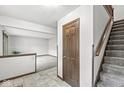 Hallway features tile flooring, wood door, and stairs to upper level at 409 Lansdowne Rd, Indianapolis, IN 46234