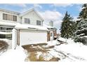 Front view of a two-story townhouse with white garage door and snowy landscape at 5921 Bastille Ln, Indianapolis, IN 46254