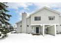 Rear view of a two-story townhouse with patio, surrounded by snow at 5921 Bastille Ln, Indianapolis, IN 46254