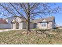A sunny day highlights this single-story home with attached two car garage, brick accents, and a mature tree at 12216 Laurelwood Ct, Indianapolis, IN 46236
