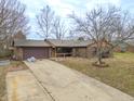 Ranch-style brick home with an attached two-car garage and a concrete driveway in a residential area at 3830 Pineview Ln, Greenwood, IN 46142