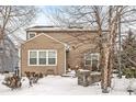 House's back elevation with patio, landscaping, and snow-covered yard at 5869 Gateway E Dr, Whitestown, IN 46075