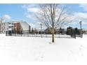 Winter scene of condo building with black metal fence at 6239 Amber Creek Ln # 104, Indianapolis, IN 46237