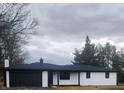 Charming exterior of a brick home with a black garage door and mature trees at 6805 E County Road 100 S, Avon, IN 46123