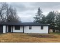 A brick home with black accents on a lush, green lot with mature trees at 6805 E County Road 100 S, Avon, IN 46123