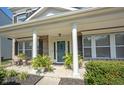 Charming front porch with columns, seating area, and a blue front door at 10406 Corning Way, Fishers, IN 46038
