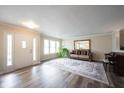 Bright living room featuring wood-look floors, a large mirror, and comfortable seating at 10406 Corning Way, Fishers, IN 46038