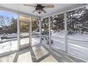 Bright, screened porch with ceiling fan and view of snowy backyard at 10896 Camden Ct, Fishers, IN 46038