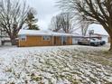 Brick ranch home with a snow-covered yard at 1729 Bittersweet Dr, Anderson, IN 46011