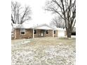 Ranch-style brick home with attached garage and snowy lawn at 2006 E 44Th St, Anderson, IN 46013