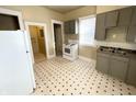 Kitchen with gray cabinets, white appliances, and black and white tile floor at 2817 N New Jersey St, Indianapolis, IN 46205