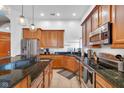 Spacious kitchen featuring granite countertops, wood cabinetry, and modern lighting fixtures at 304 N College Ave # Apt A, Indianapolis, IN 46202