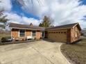 Lovely brick home with attached garage, complemented by mature trees and a concrete driveway at 3699 Lisa Ln, Plainfield, IN 46168