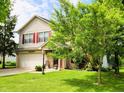 Inviting two-story home with a well-manicured lawn and mature trees at 5340 Thompson Park Blvd, Indianapolis, IN 46237