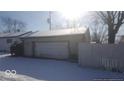 Single car garage with white door and snow on roof at 5473 E 19Th St, Indianapolis, IN 46218