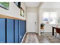 Bright entryway features wainscoting, hardwood floors, a patterned rug, and a front door at 5766 Aleppo Ln, Greenwood, IN 46143