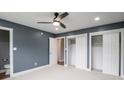 Spacious bedroom with a ceiling fan, large closets, plush carpet, and an ensuite bathroom at 901 N 700 W, Greenfield, IN 46140