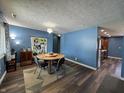 Dining room features a wood table and chairs, a large photo collage, and hardwood flooring at 975 Stonegate Rd, Greenwood, IN 46142