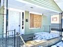 Front porch with snow and boarded window at 1218 N Ewing St, Indianapolis, IN 46201