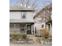 Two-story home with gray siding, front porch, and stone retaining wall at 1421 E New York St, Indianapolis, IN 46201
