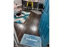 Dark hardwood floors, teal door, welcome mat, and a rug at 34 Iowa St, Indianapolis, IN 46225