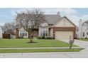 Two-story house with brick and siding, attached garage, and landscaping at 6023 Twyckenham Dr, Indianapolis, IN 46236