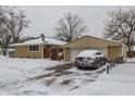 Tan single-car garage with a car parked inside, snow on the ground at 7570 E 49Th St, Indianapolis, IN 46226