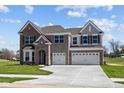 Attractive brick home featuring a spacious driveway leading to a three-car garage at 1069 Ridgevine Rd, Greenwood, IN 46143