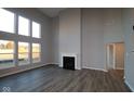 Bright living room featuring soaring ceilings, large windows, a fireplace, and hardwood floors at 1069 Ridgevine Rd, Greenwood, IN 46143