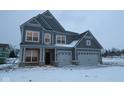 Two-story home with a two-car garage, gray siding, and a covered front porch during the winter season at 1123 Ridgevine Rd, Greenwood, IN 46143