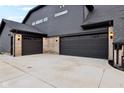 Two-car garage with dark gray doors and exterior lighting at 12458 Palmetto Bay St, Fishers, IN 46037