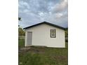 White vinyl siding with black window frames and gray door on the side of the house at 2722 Collier St, Indianapolis, IN 46241