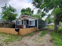 Traditional house with a cozy porch, a wooden fence, and a gravel driveway surrounded by trees at 2817 S Rybolt Ave, Indianapolis, IN 46241