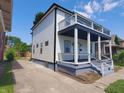 Side view of a two-story house with white siding and a balcony at 3156 Graceland Ave, Indianapolis, IN 46208