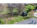 Aerial view showcasing the backyard, shed, and green space with mature trees in a desirable neighborhood at 7709 Santolina Dr, Indianapolis, IN 46237
