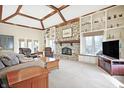 Spacious living room with stone fireplace, built-in shelving, and vaulted ceilings at 105 S Maxwell Ct, Zionsville, IN 46077