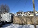Back of house with wooden fence and camper in snowy yard at 1713 W 11Th St, Muncie, IN 47302
