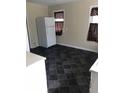 Simple kitchen with white appliances and dark-colored tile floor at 1713 W 11Th St, Muncie, IN 47302