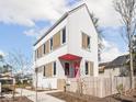 Charming two-story home with white siding, contrasting trim, pink door, and a cute picket fence at 220 N Beville Ave, Indianapolis, IN 46201