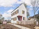 Charming two-story home with white siding, contrasting trim, pink door, and a cute picket fence at 220 N Beville Ave, Indianapolis, IN 46201