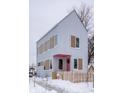Modern two-story house with light grey siding, tan accents and pink door, snowy yard at 220 N Beville Ave, Indianapolis, IN 46201